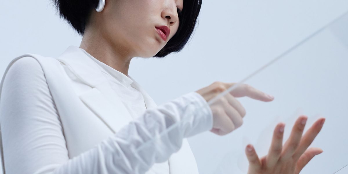 A person interacting with an unseen advanced interface, simulating gestural control or holographic manipulation, reflecting human-computer interaction concepts.