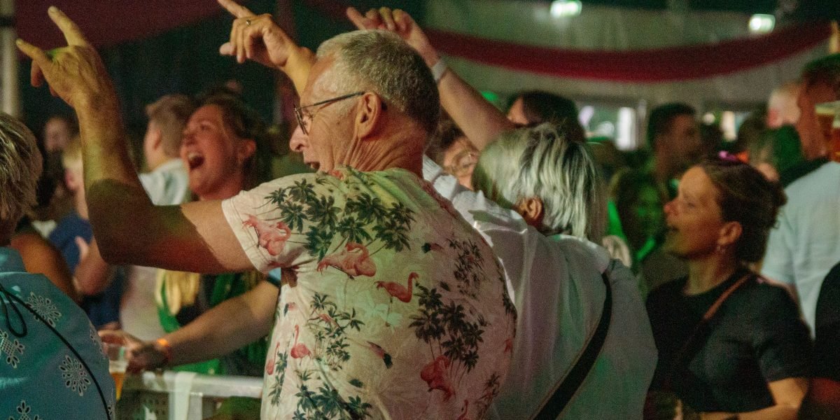 A lively scene at a festival or conference, showing people networking, sharing ideas, and enjoying the community spirit around film and technology.