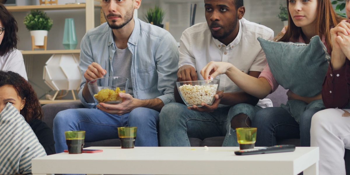 Friends animatedly discussing a film, highlighting the social aspect of enjoying niche sci-fi and AI-driven stories.