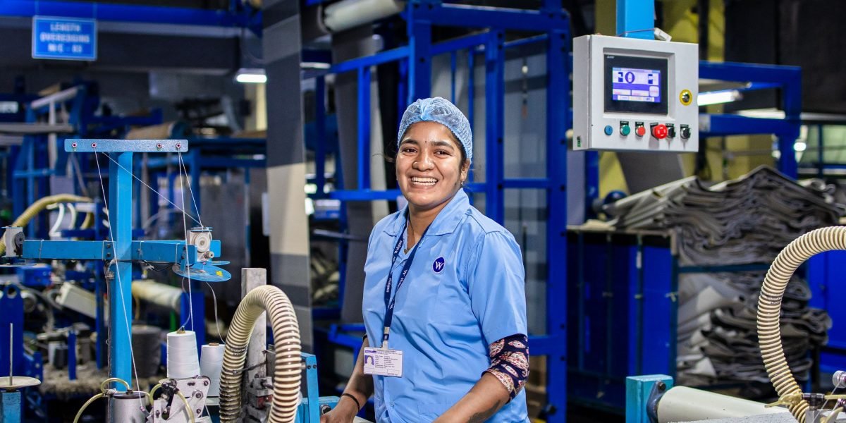 A human worker oversees a modern automated warehouse, illustrating physical AI's role in industrial settings.